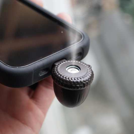 Acorn Diffuser mini essential oil diffuser plugged into a smartphone